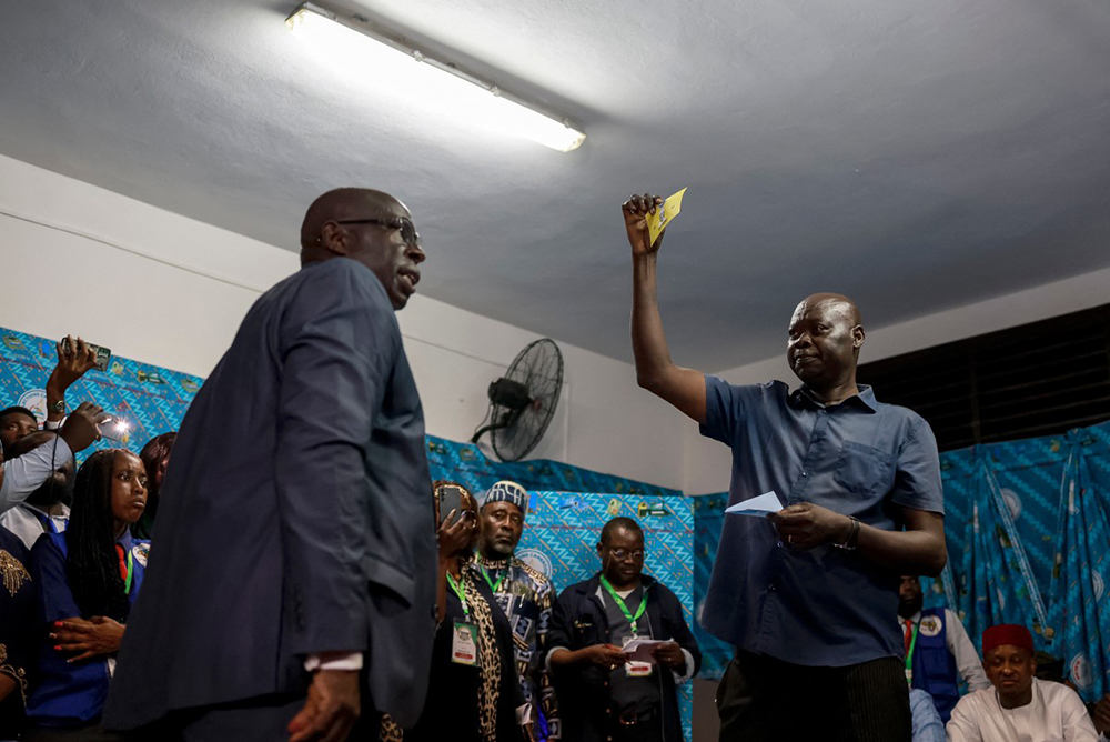 A member of Elecam (Cameroon Electoral Board) holds a ballot paper of Cameroonian presidential candidate Issa Tchiroma Bakary while votes are counted at the Bastos public school polling station in Yaounde, on October 12, 2025 after polls closed in Cameroon's presidential election.