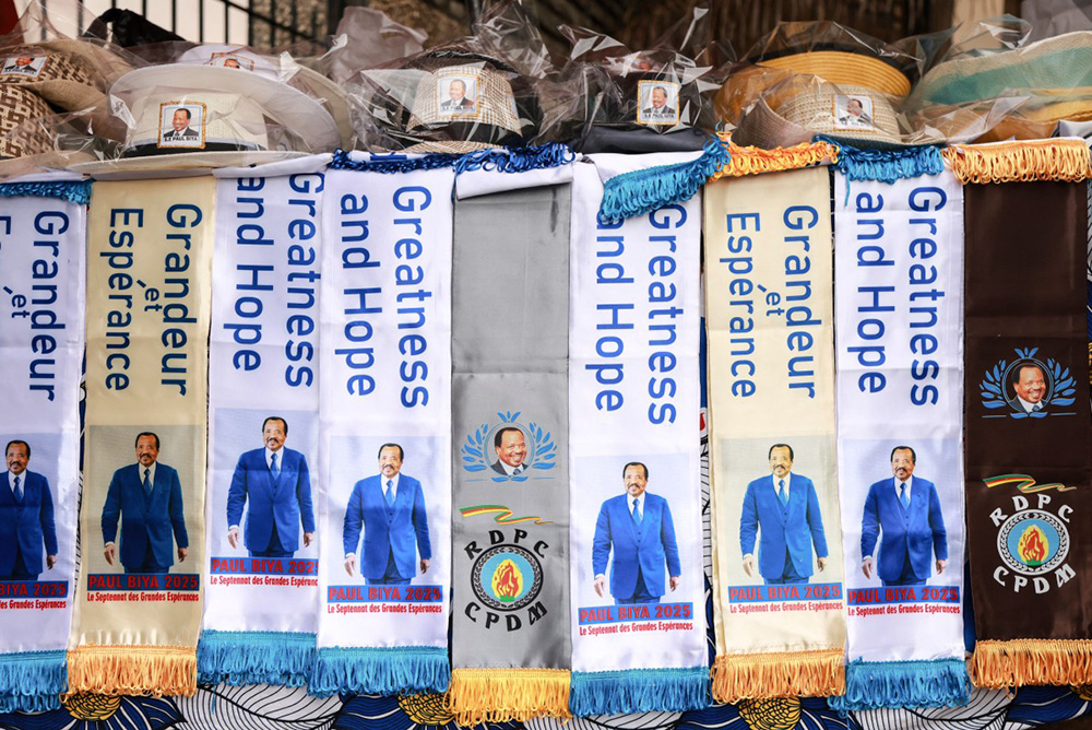 Items bearing the image of Paul Biya, President of Cameroon and presidential candidate for the Cameroon People's Democratic Movement (CPDM), are displayed on stands in front of the party headquarters, in Yaounde, on October 10, 2025. (Photo by Daniel Beloumou Olomo / AFP)