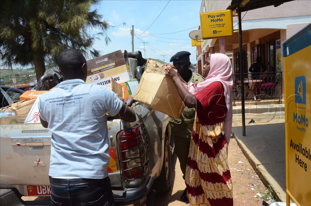 Shadidah Nabakooza (right), an attendant at Rwenkanja Farm Supply in Biharwe town, Mbarara City North and MAAIF officials loading expired agricultural products in a shop during the crackdown on counterfeit agro-inputs on Friday.