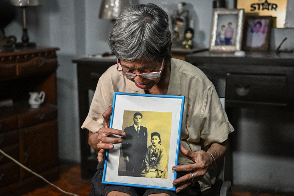 In this photo taken on August 8, 2025, Maria Corazon Nagai shows a photo of her father Tokuhiro Nagai, a civil engineer, at her home in Manila. Nagai, an 82-year-old Manila grocer, widow and mother of three, gave up her Philippine passport for a Japanese one last April with PNLSC's help. (Credit: AFP)