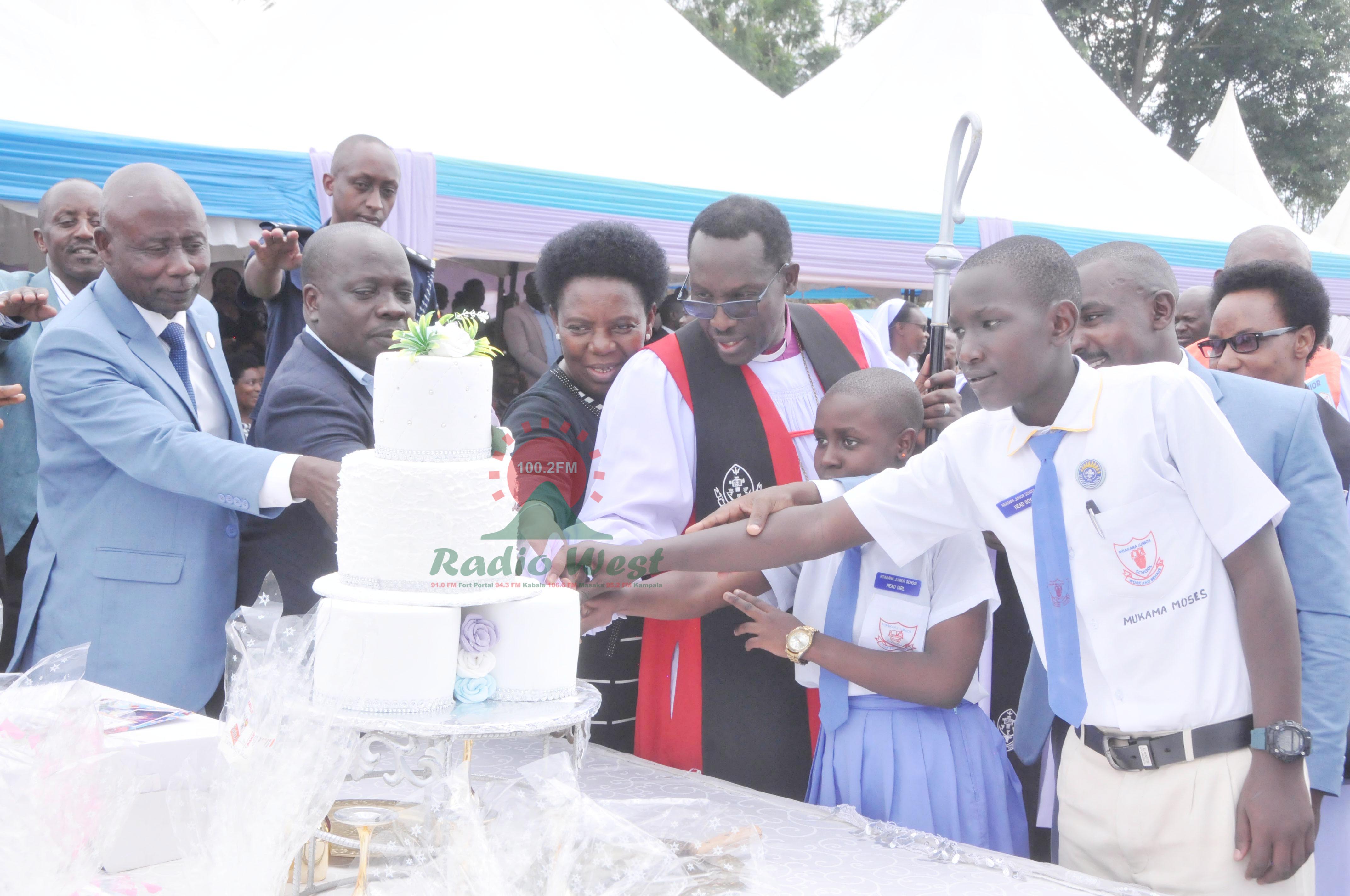Biishopu Sheldon, omukazi we na Mukuru w'eishomero erya Mbarara Junior School barikushara cake n'abeegi ba P.7 ba Mbarara Junior School.