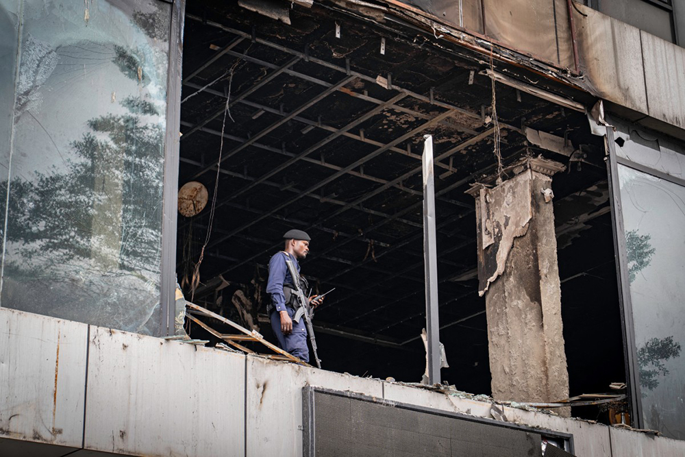 A Congolese police officer secures a wedding hall that was damaged by fire in Kinshasa on September 5, 2026.