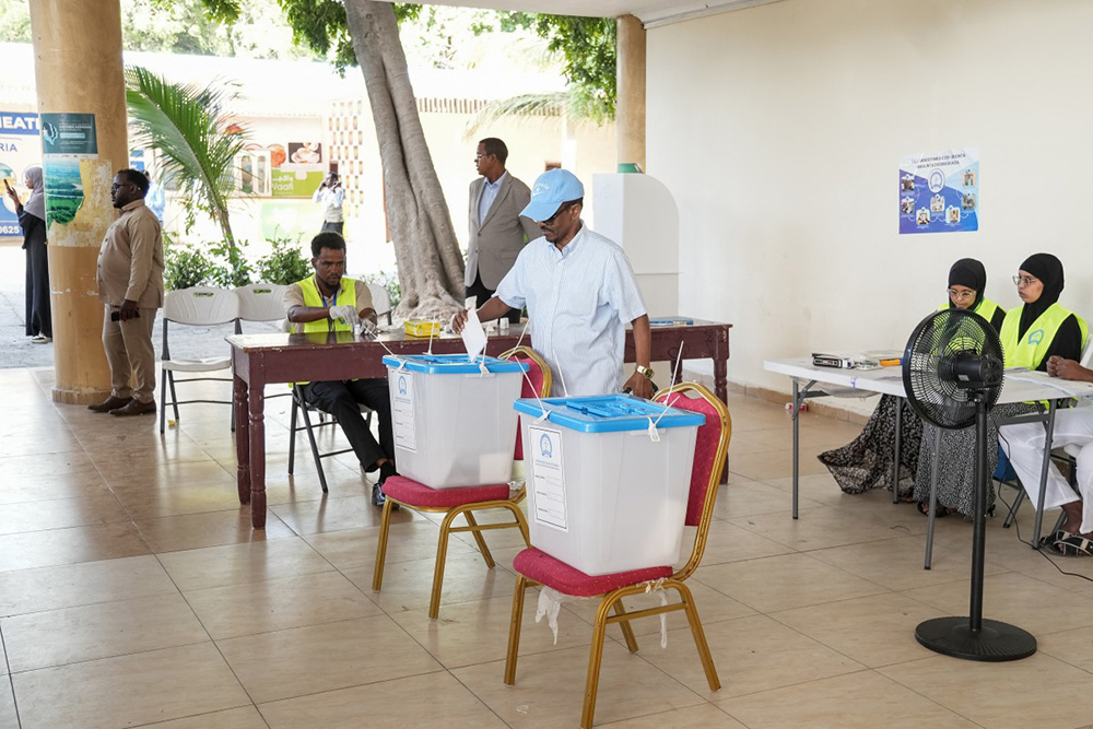 A voter casts his ballot paper at a polling station during local council elections in Mogadishu on December 25, 2025. Somalia's capital, Mogadishu, heads to the polls on December 25, 2025 for local elections, the first time in 58 years, under a complete citywide lockdown amid security concerns. (Photo by Hassan Ali ELMI / AFP)
