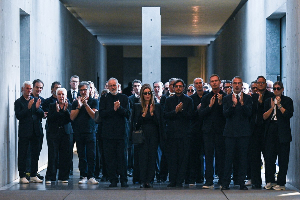 Armani's employees applaud as the hearse carrying the coffin of late Italian fashion designer Giorgio Armani leaves the Armani Theatre, in Milan on September 7, 2025. Giorgio Armani died on September 4, 2025 at 91. 