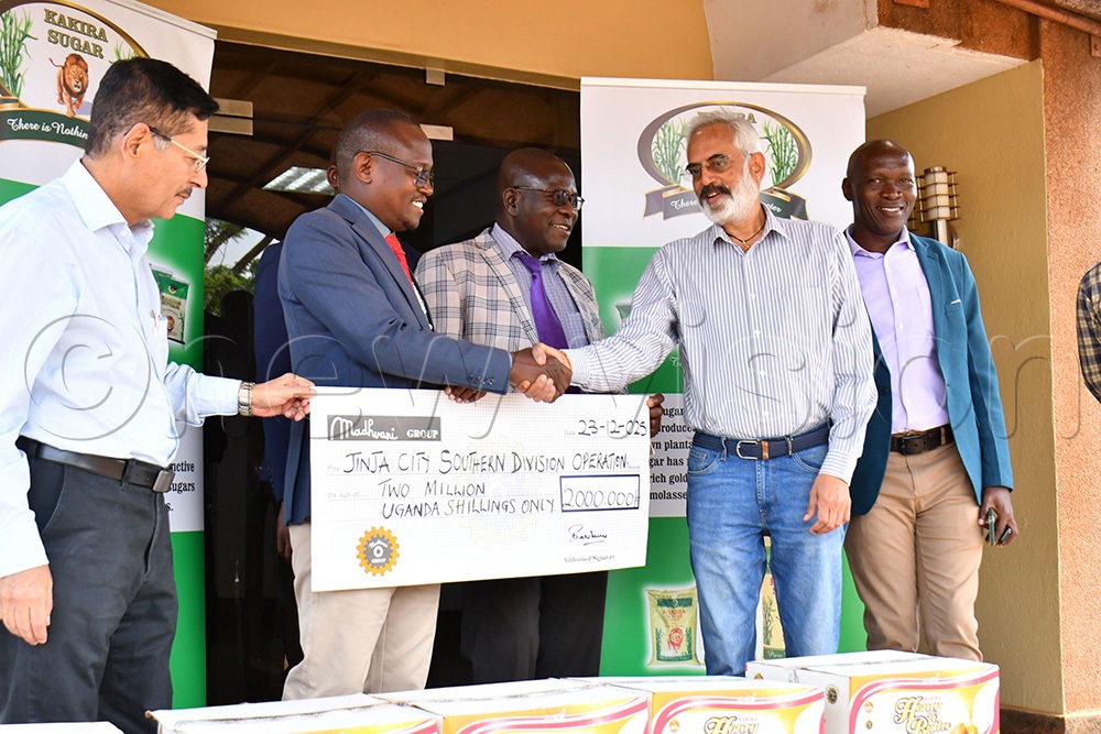 Jinja City Mayor Alton Peter Kasolo (2nd left) receiving a sh2m dummy cheque and boxes of sugar and assorted sweets from Kakira Sugar Limited's Company Secretary S.K Iyengar (2nd right) and Kakira Sugar Limited's Director of Finance Satish Sawhney (left) while at Kakira Sugar Limited factory on Tuesday. Looking on is the Jinja City Clerk Peter Mawerere (middle) and Geoffrey Muzuusa (right) the Jinja City Community Development Officer.  (Photo by Donald Kiirya)