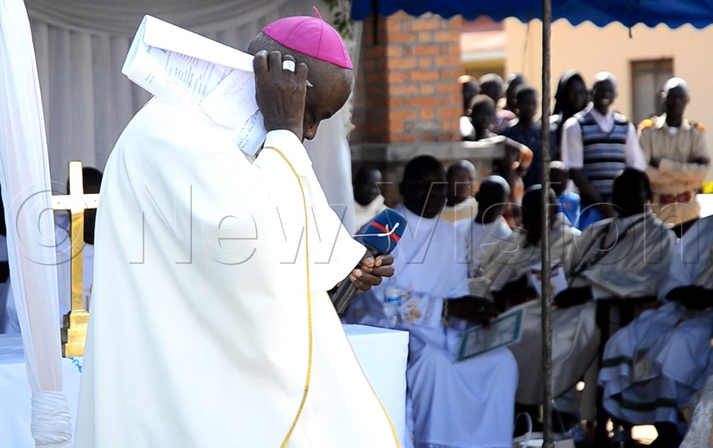 Bishop Sabino Ocan Odoki of Arua Catholic Diocese brushes away bees with his speech papers after a swarm disrupted the ordination of priests and deacons on Saturday, August 1, 2026. (Photo by Robert Ariaka)