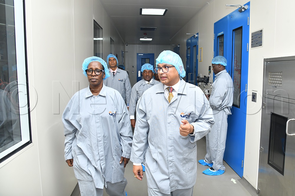 Ajay Kumar Pal, CEO of Quality Chemical Industries Limited, takes Diana Atwine, Permanent Secretary at the Ministry of Health, on a guided tour of the new facility. (Photo by Richard Sanya)