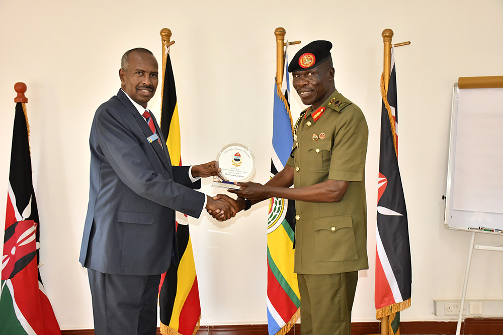 Brig Gen Alex Olupot Opollot of NDC-U hands over a medal to Maj Gen Yahya Abdi of the National Defence College Kenya (NDC-K) at the function. (Photo by Doreen Musingo)