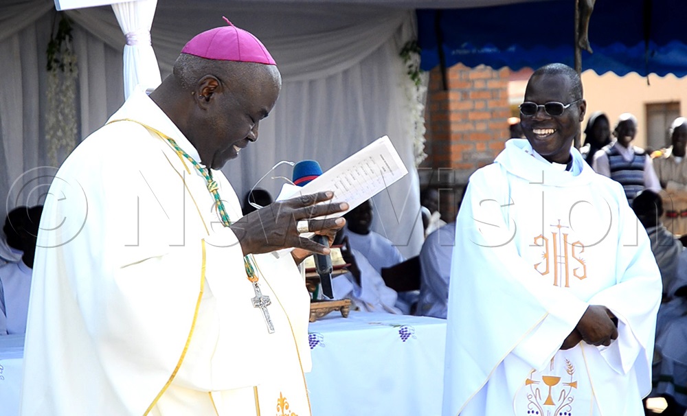Bishop Sabino Ocan Odoki of Arua Catholic Diocese and Rev. Fr Picho Epiphany share a laugh after a swarm of bees briefly disrupted the bishop's speech during the ordination ceremony on Saturday, August 1, 2026. (Photo by Robert Ariaka)