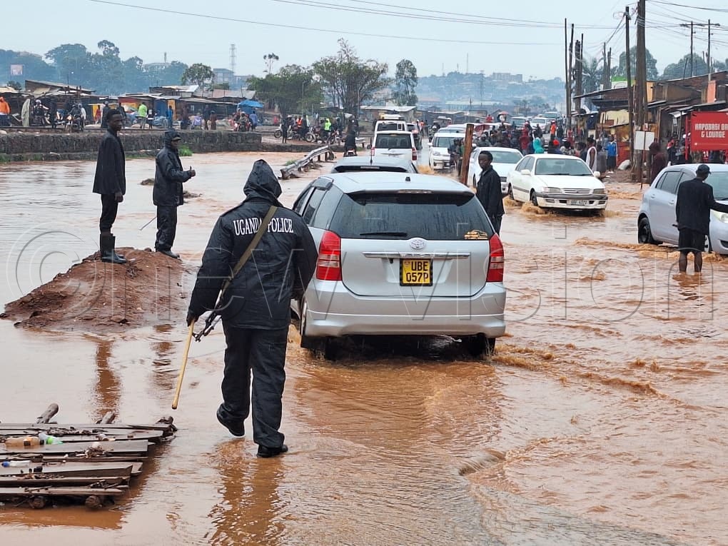 Traffic police guiding traffic at a flooded section of Kinawataka, Kampala, following a heavy morning downpour on September 17, 2026. (Credit: Mpalanyi Ssentongo)