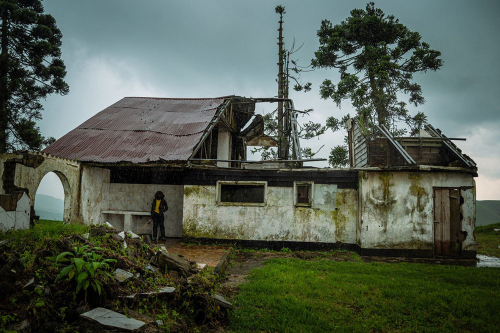   A young farmer takes shelter from the rain in a former hotel in Ruvunda that was bombed by a Congolese army drone in December 2023 on the suspicion that was used as a position by the M23 rebel group, in Mushaki on November 12, 2025. Photo by Jospin Mwisha / AFP)