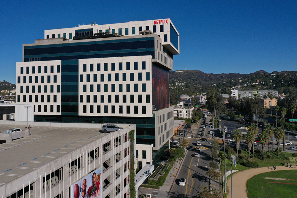 This aerial picture taken on December 5, 2025, shows the Netflix logo above Hollywood studio offices at Sunset Bronson Studios as the Hollywood sign stands on the horizon in Los Angeles, California.