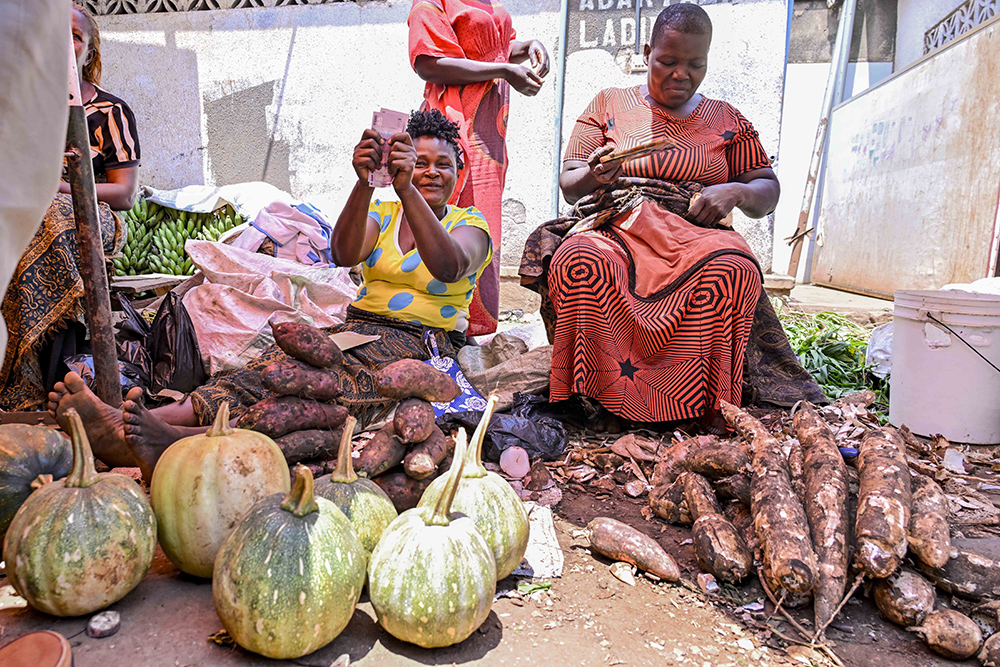 An excited market vendors in Wobulenzi shows off her cash received from President Yoweri Kaguta Museveni for financial support. (Photo by PPU/Tony Rujuta)