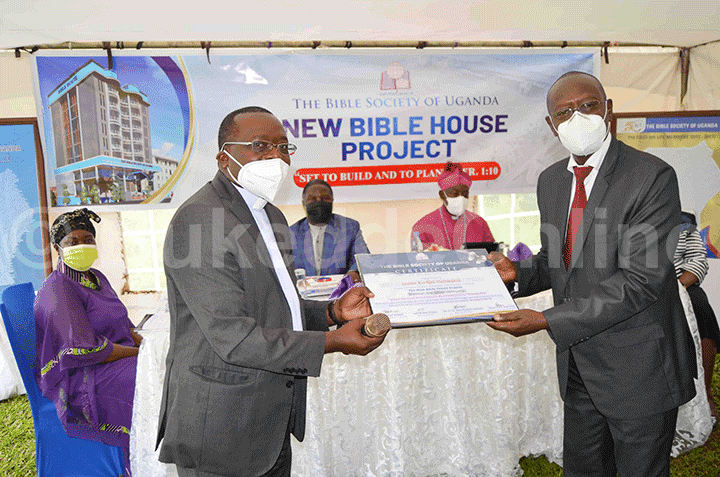 Fr. Dr. Mark Richard Ssajjabi (ku kkono) ng'akwasa Justice Ezekiel Muhanguzi ssatifikeeti ye