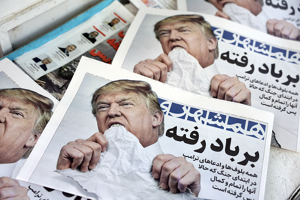 Copies of the Iranian daily newspaper Hamshahri bearing an image of the US president and a headline that reads "Gone with the wind" are displayed at a kiosk in Tehran on June 18, 2026.