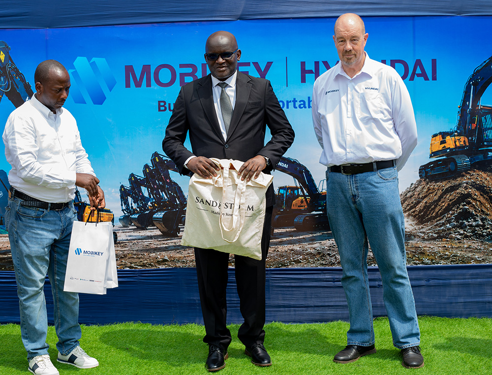 Dr Eng. Timothy Tebesigwa preparing to pose for a picture with Mark van Rooyen, the General Manager of Mobikey Uganda. (Photo by Moses Kigongo)