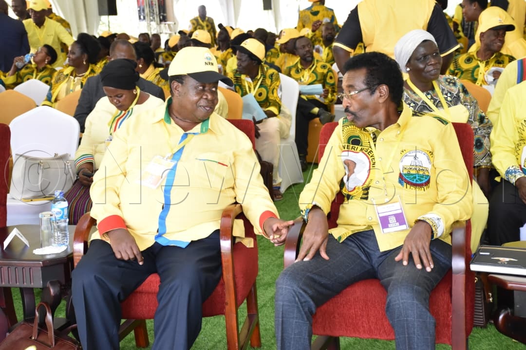 Kahinda Otafiire sharing a light moment with Jim Muhwezi.