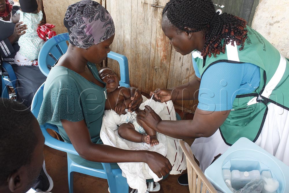 A medic immunizes a child during a health camp on Tuesday at Busana landing site along Lake Victoria, Busana village, Nyenga Sub- County in Buikwe district. (Credit: Douglas Mubiru)