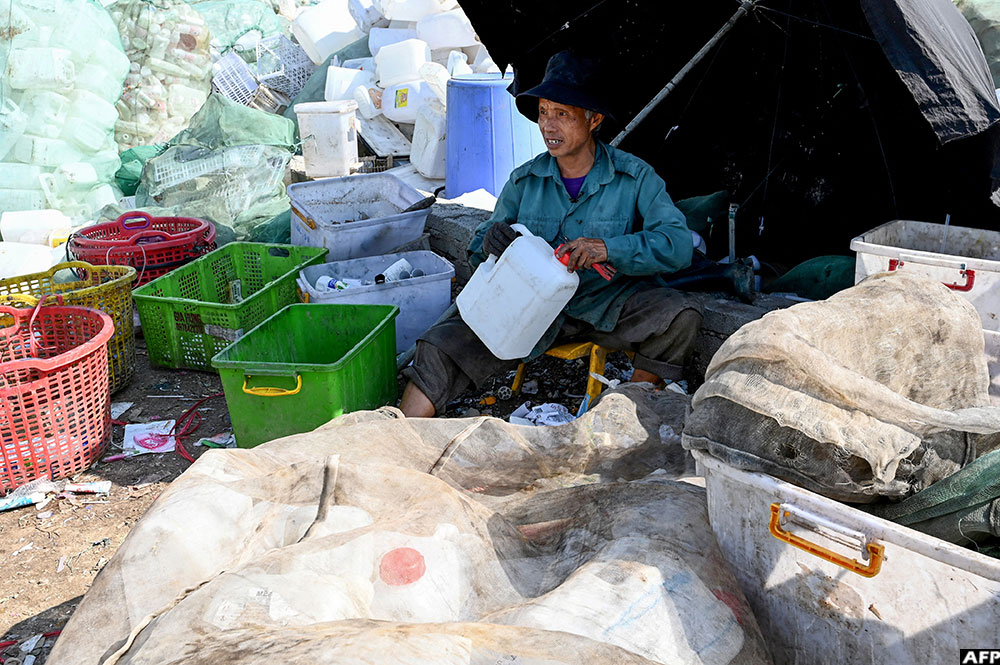  A man sorts plastic waste in a village on the outskirts of Hanoi
