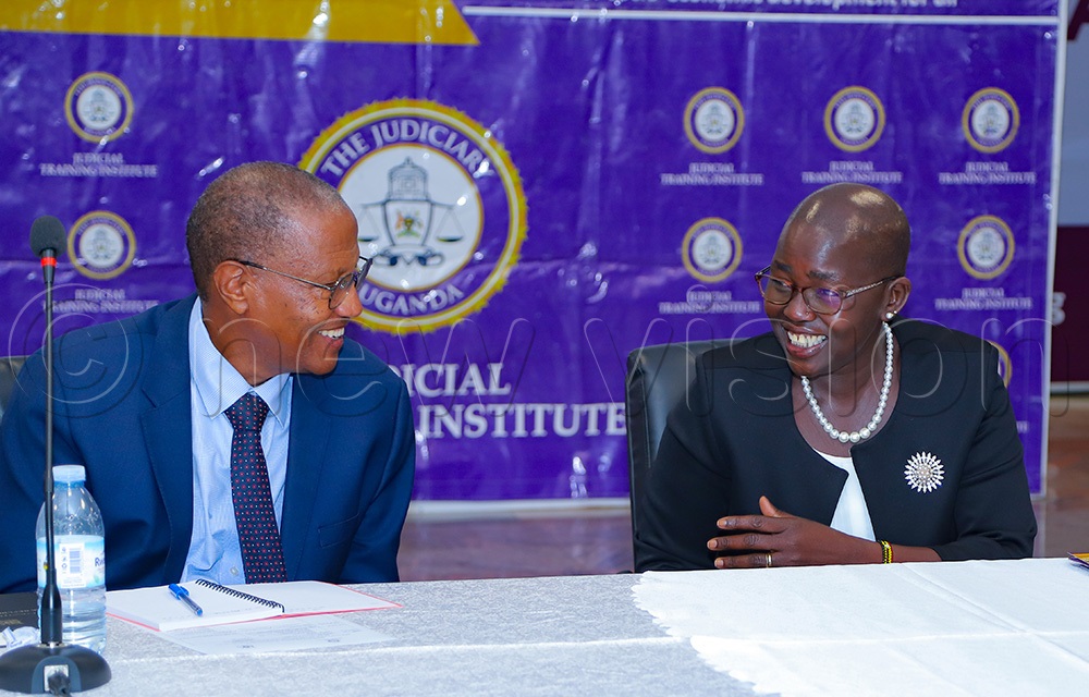Principal Judge Jane Frances Abodo interracting with former Deputy Chief Justice Richard Buteera during the roundtable discussions on land matters on Friday May 22, 2026. (Photo by Farooq Kasule)
