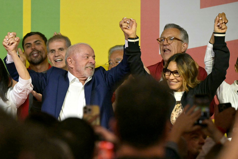 Brazil's President and re-election candidate for the Workers' Party (PT) Luiz Inacio Lula da Silva and First Lady Rosangela Janja da Silva raise their arms following the partial results of the presidential election in Sao Paulo, Brazil on October 4, 2026. (Credit: AFP)