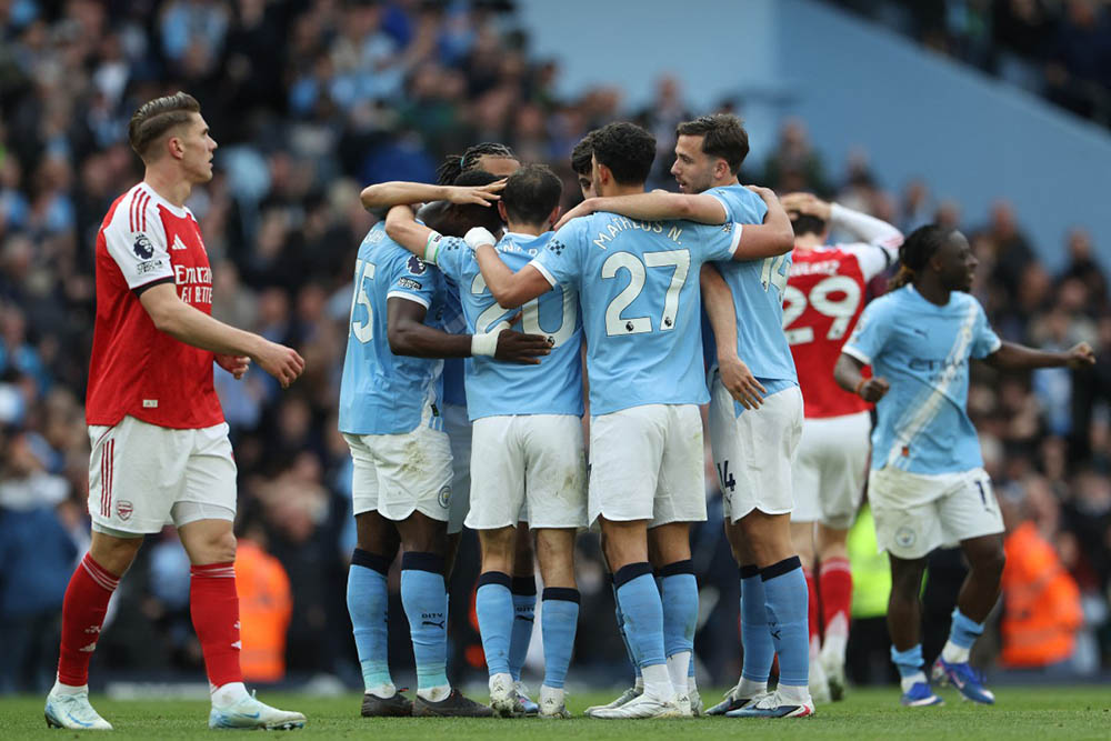 Manchester City players celebrate at the end of the English Premier League football match between Manchester City and Arsenal at the Etihad Stadium in Manchester, north west England, on April 19, 2026. (Credit: AFP)