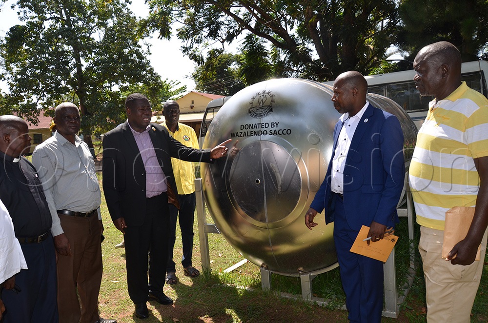 Minister of Defence and Veterans Affairs, Jacob Markson Oboth, (third from left) hands over the stainless steel water tanks. (Photo by Faustine Odeke)