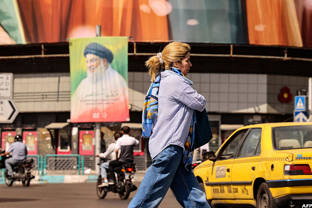 An Iranian woman walks past a billboard depicting slain Lebanese Hezbollah leader Hassan Nasrallah in Tehran on September 28, 2025