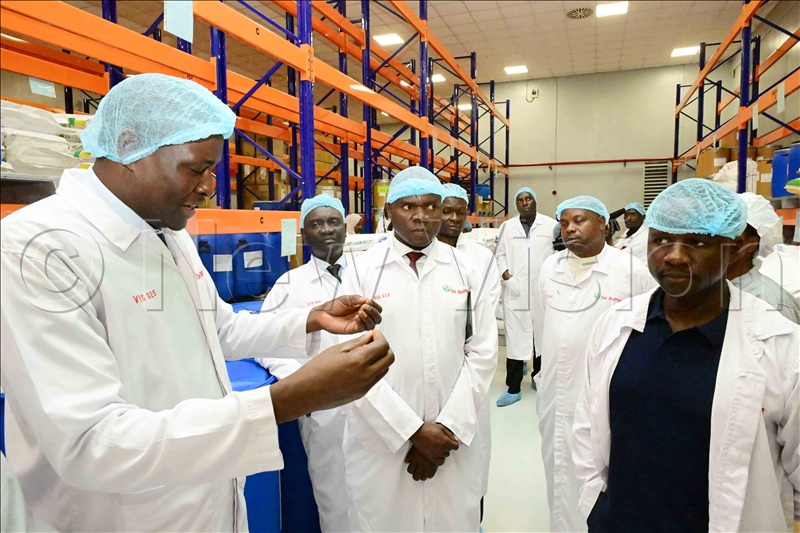The founder of Dei Biopharma pharmaceutical factories in Matugga, Wakiso District, Dr. Mathias Magoola (L), explains to a team from Zimbabwe what they manufacture at the facility. Centre is Brig General Maxwell Masuku, who led the team from Zimbabwe. August 19, 2026.