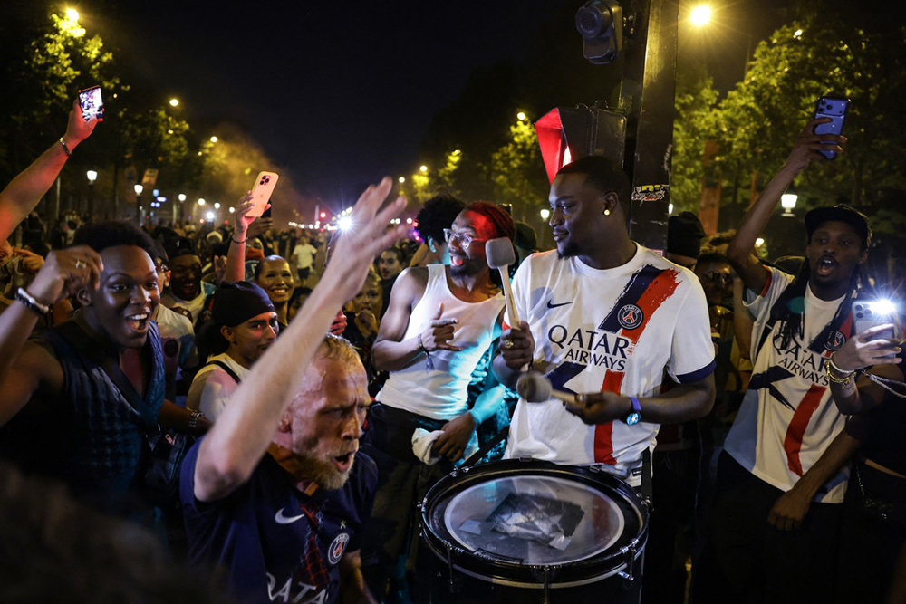 PsPSG supporters cheer and play a drum on the Champs-Elysees Avenue as they celebrate the club won the UEFA Champions League final between Paris Saint-Germain (PSG) and Arsenal FC played in Budapest, in Paris on May 30, 2026.