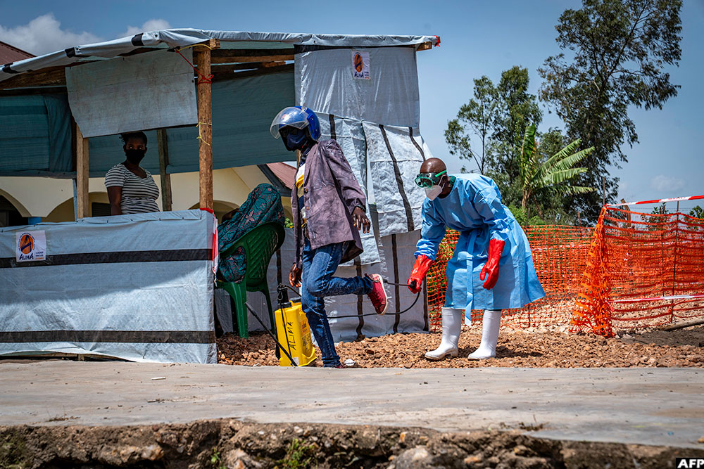 Dieudonné Sezabo, a health worker, decontaminates the clothing of a motorcycle taxi driver who transported a patient suspected of having Ebola to the Rwampara Hospital in Ituri, in the eastern DRC, on May 26, 2026