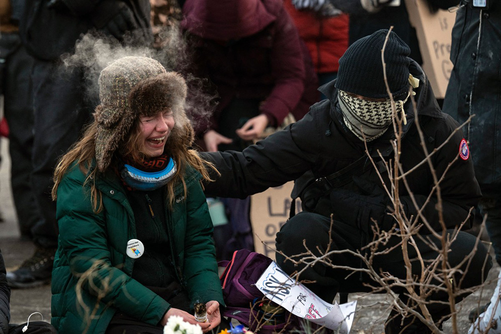 A woman cries at a makeshift memorial in the area where 37-year-old Alex Pretti was shot dead by federal immigration agents earlier in the day in Minneapolis, Minnesota, on January 24, 2026. (Photo by ROBERTO SCHMIDT / AFP)