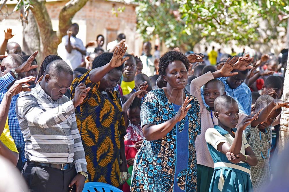 Parents and children together with teachers pray for the family of departed Okedi.