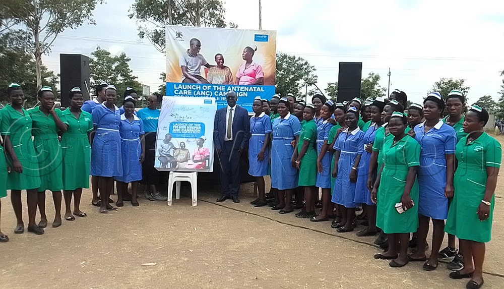 Dr Ronald Miria Ocatre, the Assistant Commissioner in charge of health promotion and strategic health communication wearing a coat, with nurses in Arua District. (Credit: Robert Ariaka)