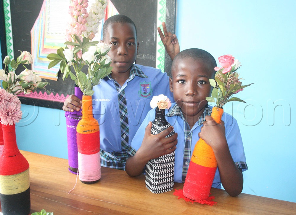 Pupils showcase some of the recycled bottles. (Photo by Maureen Nakatudde)