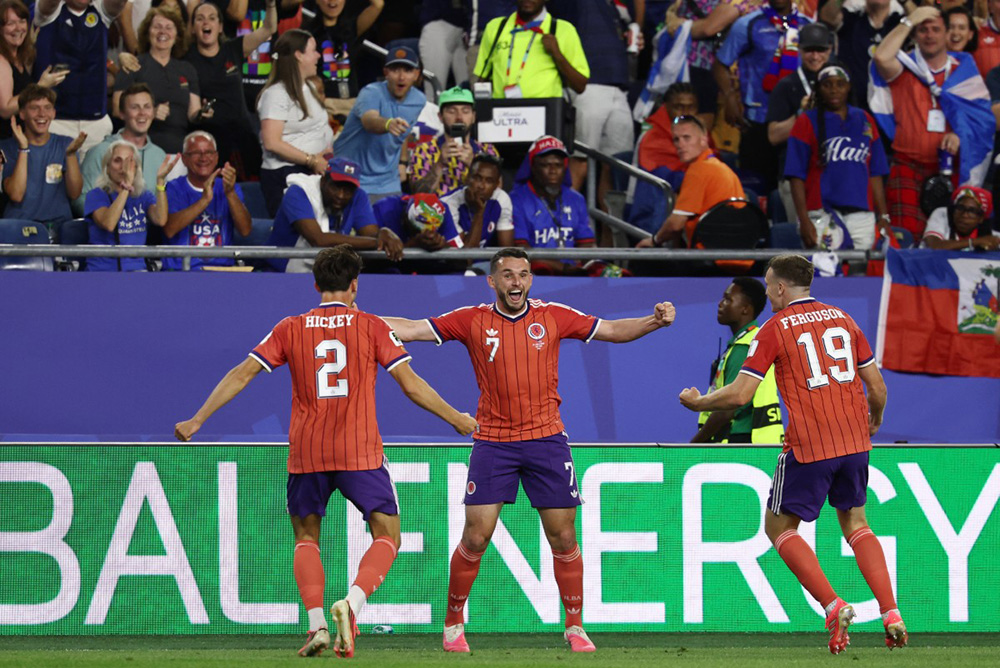 WScotland's midfielder #07 John McGinn celebrates with teammates defender #02 Aaron Hickey and midfielder #19 Lewis Ferguson after scoring his team's first goal during the 2026 World Cup Group C football match between Haiti and Scotland at the Boston Stadium in Foxborough on June 13, 2026. (Photo by FRANCK FIFE / AFP)