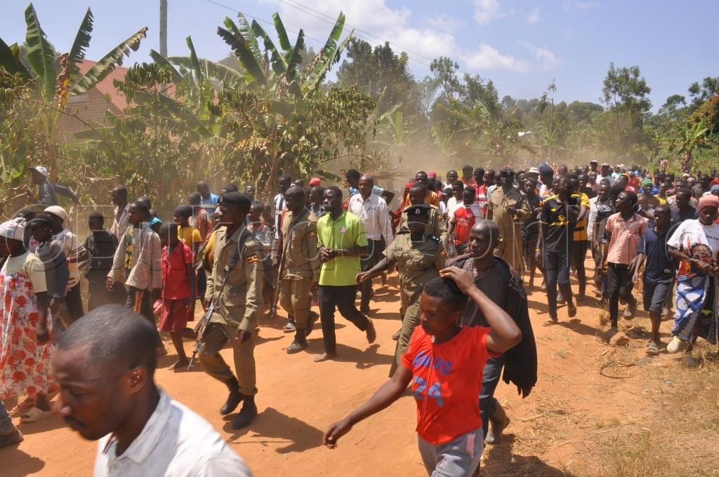 Abatuuzeb'e Bufumbe Nga Bawerekera Poliisi, Okello bwe yabadde agitwala awali omulambo gw'omwana.