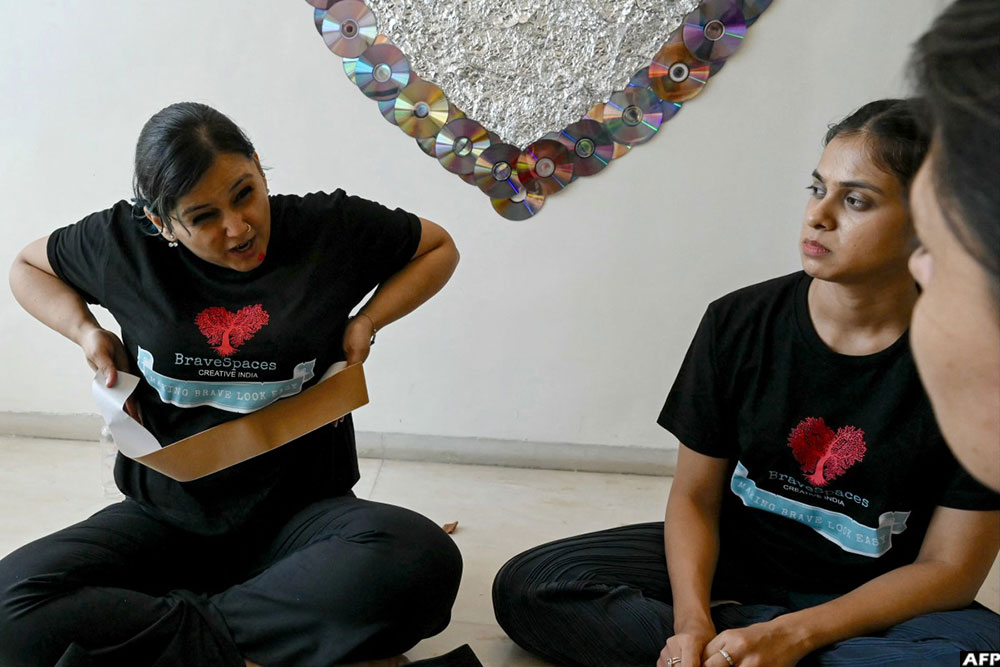 Intimacy director and BraveSpaces Creative India founder Neha Vyaso (L) demonstrating the application of a breast tape as her assistant Sanah Oberoi watches during a mock intimacy workshop for an upcoming project in Mumbai. (AFP)