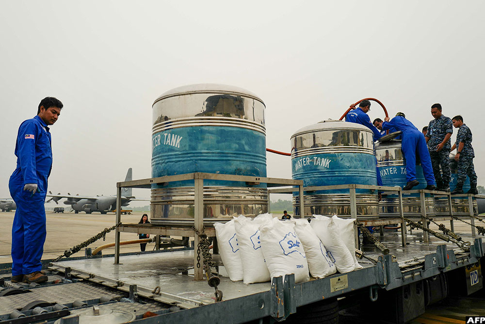 Authorities mix sodium chloride and water in a cloud seeding process at the Royal Malaysian Air Force Military Base in Subang on September 19, 2019