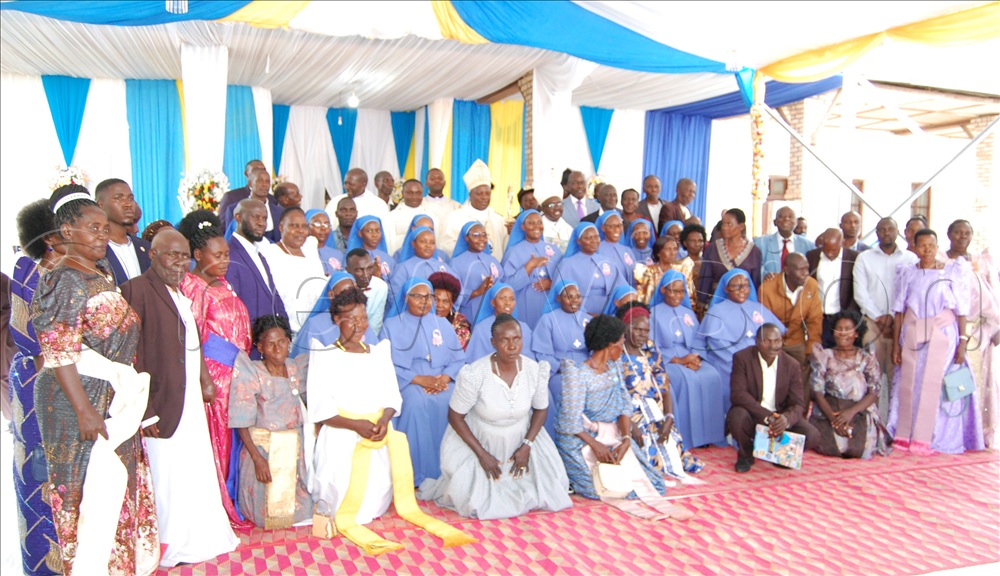 The Bannabiikira/Bwanda Sisters who took their perpetual vows sharing a photo moment with their parents/relatives and the Catholic prelates  after mass.