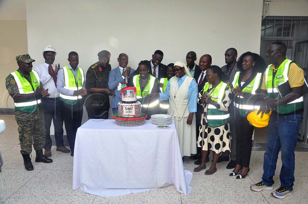 Mugira (Fourth from Left), Nawangwe (Fifth left) participate in cutting the cake for the handover of Mary Stuart Hall of Makerere University. The function took place at Makerere University. (Credit: John Odyek)