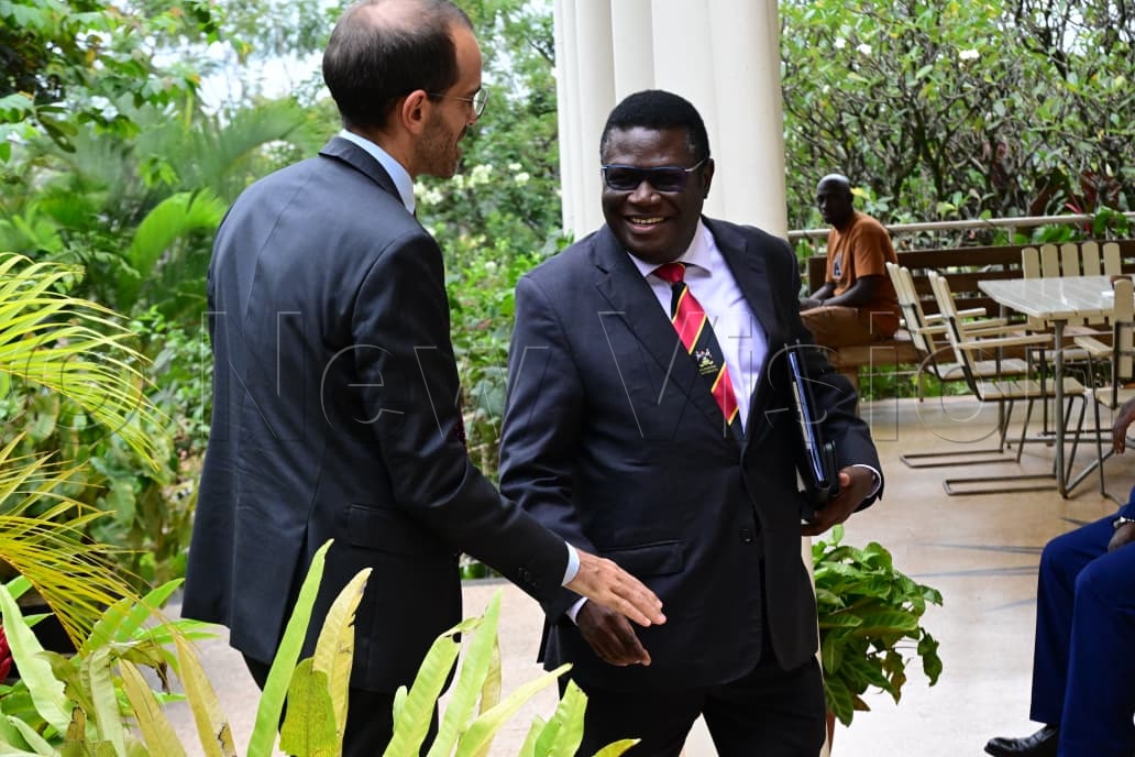 Minister for Justice and Constitutional Affairs, Norbert Mao interacting with a guest.