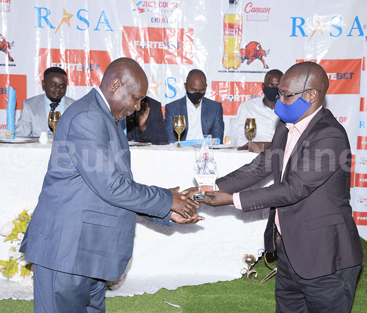 Kato Kawuma akulira ebyemizannyo mu lupapula lwa Bukedde ku ddyo ng'akwasa Michael Arereng ku kkono engule ya 'Life Achiver's Award'.