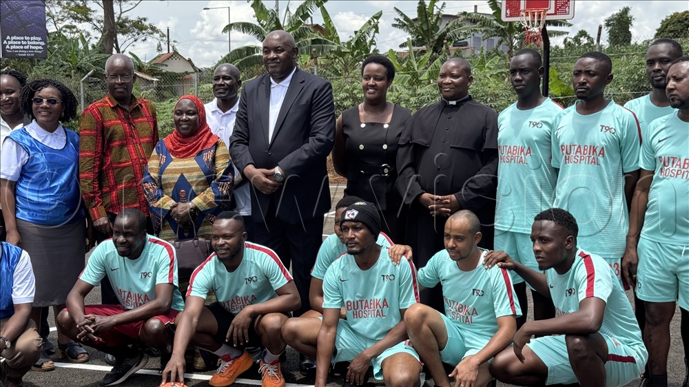 Some of the players of Watoto and Butabika pose for a group photo with the health minister Baryomunsi