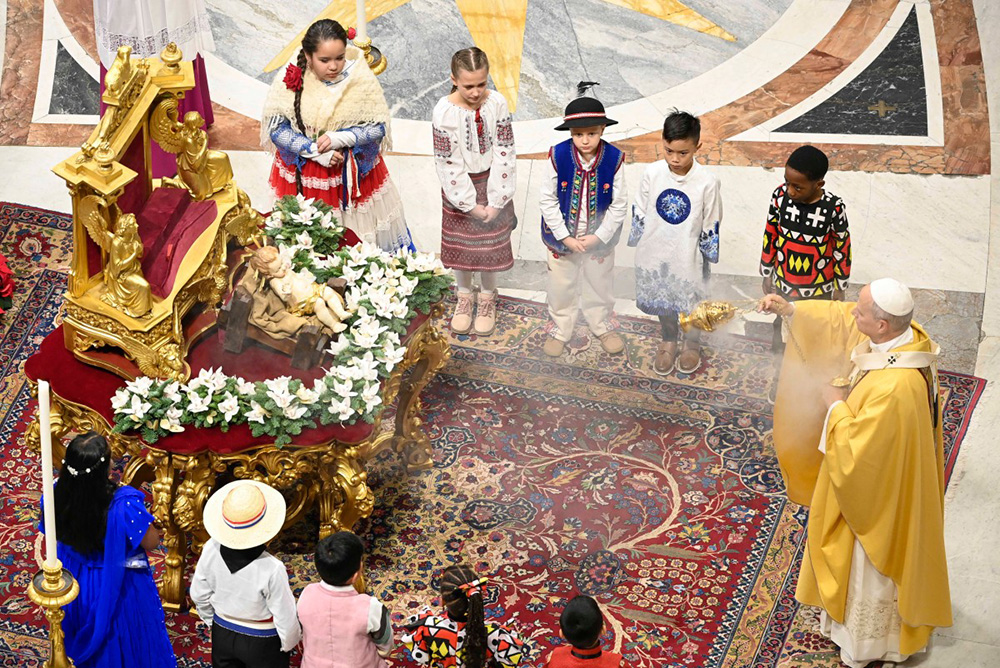 Pope Leo XIV (R) spraying incense on the statue of Baby Jesus at the end of the Christmas Eve mass at St Peter's Basilica at the Vatican. (Photo by Matteo Pernaselci / VATICAN MEDIA / AFP)