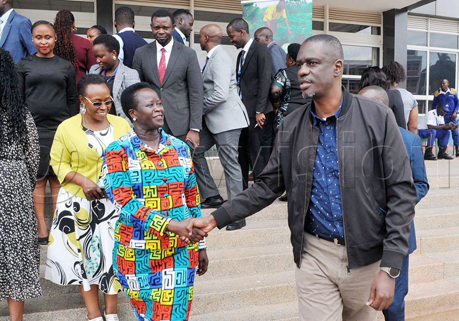 Santa Sandra Alum (left), Minister of State for Economic Monitoring, chats with Dennis Galabuzi Ssozi, National Coordinator of the Parish Development Model (PDM), after a validation workshop for the PDM results at the National ICT Hub