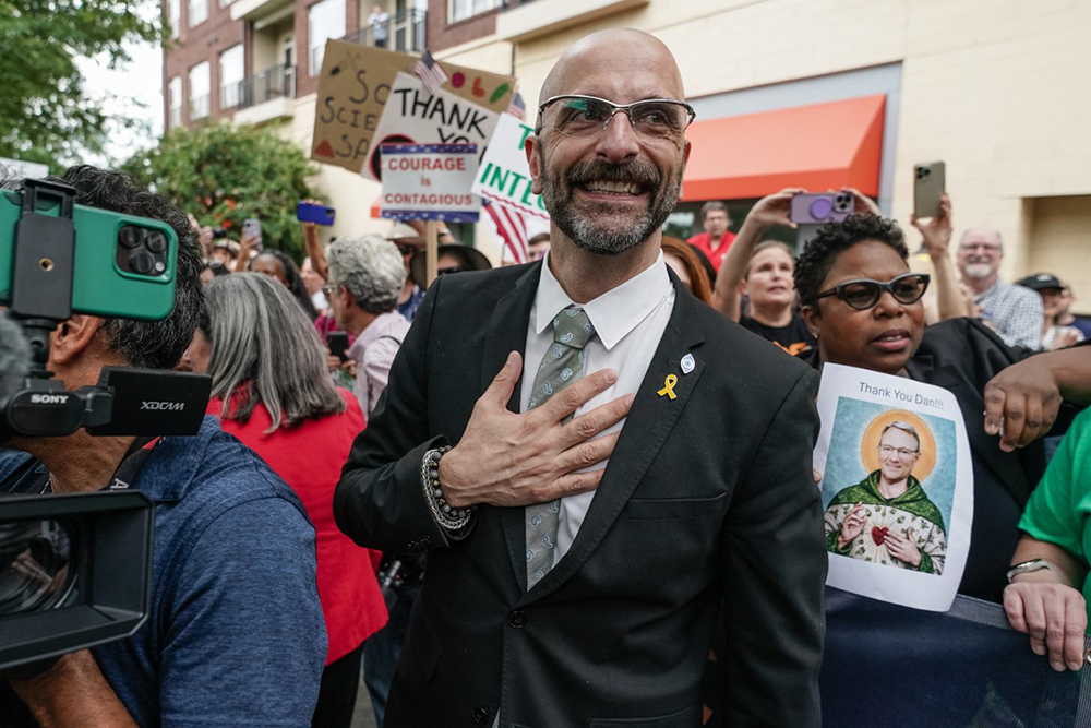 Former Centers for Disease Control (CDC) official Demetre Daskalakis places his hand over his heart as employees and supporters of the CDC cheer and clap to honor him, Dan Jernigan, and Deb Houry outside its global headquarters on August 28, 2025 in Atlanta, Georgia.