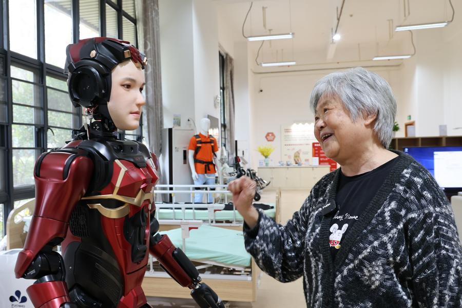 A senior resident interacts with "Xia Lan," a humanoid robot, at Shenzhen Nursing Home in Shenzhen, south China's Guangdong Province, March 3, 2025. (Xinhua/Liang Xu)