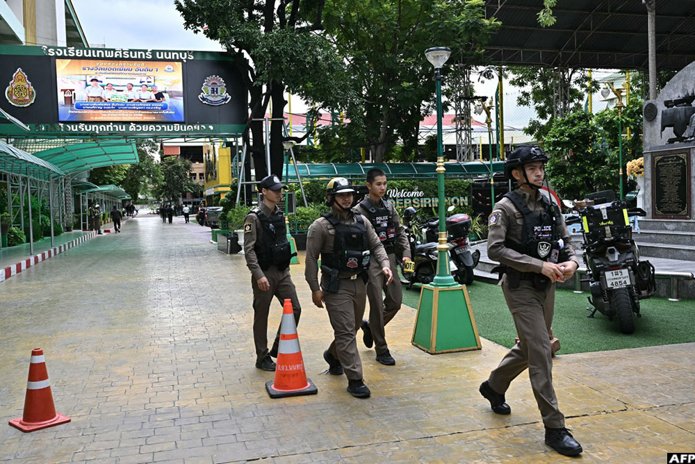 Police walk at a school premises following a shooting in Bang Kruai district, Nonthaburi province, north of Thailand's capital Bangkok, on August 7, 2026.