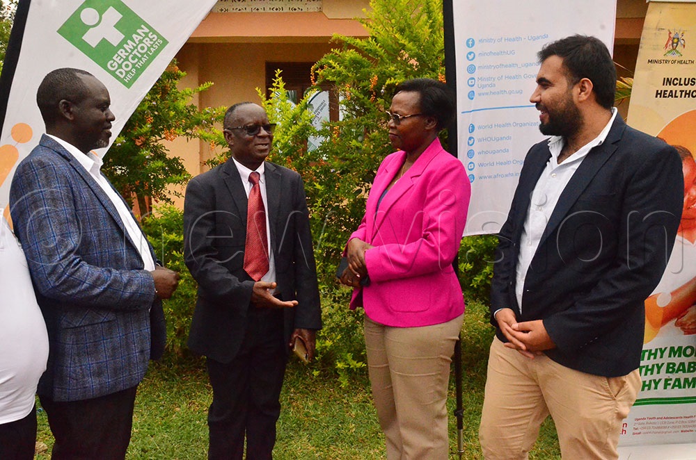The commissioner community health, Dr George Opentho chatting with from the Ministry of Health, WHO and Butebo local district officials. (Credit: Agnes Kyotalengerire)
